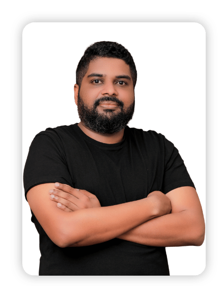 Bearded man in a black t-shirt with arms crossed against a white studio backdrop.